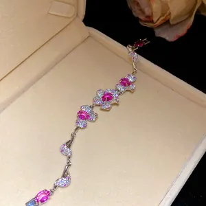 Funkelndes Blumenarmband mit rosa Zirkonia und weißen Steinen in einer beigen Box
