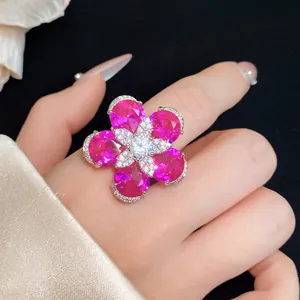 Detaillierte Nahaufnahme eines funkelnden rosa Zirkon-Blumenrings an einer Hand.