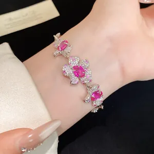 Nahaufnahme eines eleganten Blumenarmbands mit lebhaften rosa Edelsteinen und weißen Zirkonia