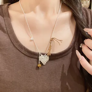 Detail view of a minimalist woven heart pendant necklace worn on a fashion model.