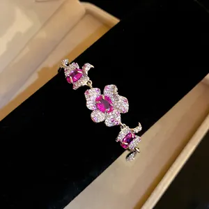 Detailansicht eines eleganten silbernen Blumenarmbands mit funkelnden rosa Zirkonia.