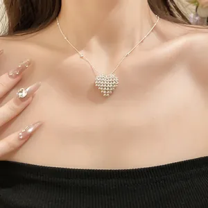 Close-up of minimalist silver woven heart pendant necklace on model's collarbone
