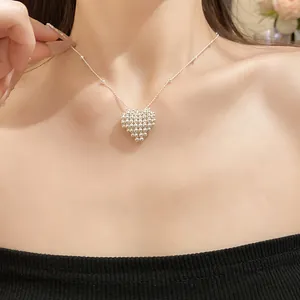 Close-up of a silver beaded woven heart pendant necklace worn on a woman's neck