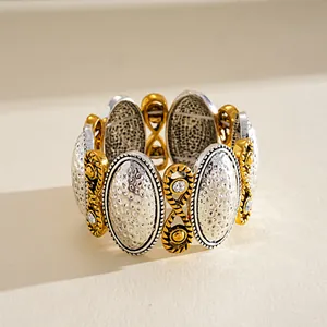 Dettaglio del bracciale vintage bicolore con placche ovali martellate e piccoli strass.
