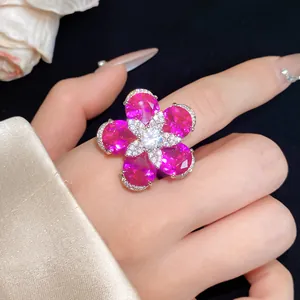 Nahaufnahme eines exquisiten magenta Edelstein-Blumenrings an einer eleganten Hand
