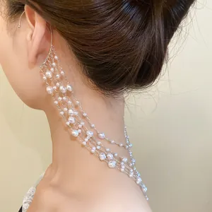 Close-up detail of elegant multi-layered pearl tassel ear cuff earring on model