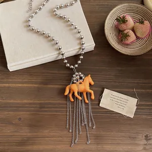 Cute orange resin horse pendant necklace with silver beaded chain and tassel detail