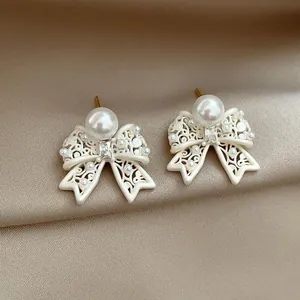 Detail view of French vintage hollow bow earrings with elegant pearl accents.