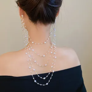 Detailed back view of elegant multi-layered pearl beaded ear hook jewelry on model