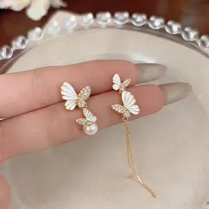 Elegant asymmetric butterfly earrings with white enamel, rhinestones and pearl detail