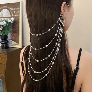 Detailed view of elegant multi-strand pearl ear cuff draping over long brown hair
