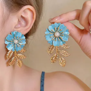 Elegante hellblaue Emaille-Blumenohrringe mit Perle und goldenen Blattquasten-Anhängern.