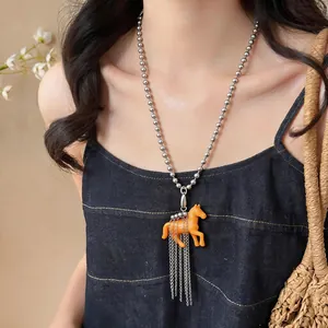 Cute resin horse pendant sweater necklace with silver ball chain tassels on model