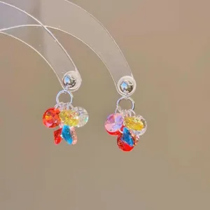 Primer plano de pendientes coloridos estilo dopamina con cuentas facetadas en pernos de plata