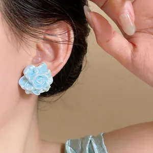 Dettaglio ravvicinato dell'orecchino a fiore in resina azzurra con petali eleganti in 3D