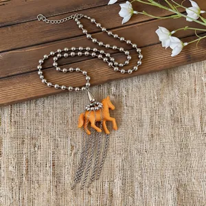 Playful resin orange horse pendant sweater chain with silver bead tassel details