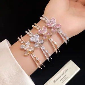 Detail view showing four elegant zircon butterfly double-layered open bangles on a wrist