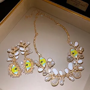 Elegant evil eye jewelry set featuring pearls and rhinestones on a gold jewelry tray