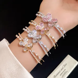 Detailed view of sparkling zircon butterfly double-layered open bangles on wrist
