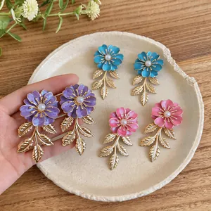 Detailansicht der farbenfrohen Emaille-Blumenohrringe mit goldenen Blättern und Perlen
