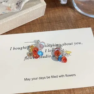 Detalle macro de pendientes de borlas de cuentas de colores estilo dopamina en tarjeta