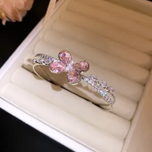 Detail of a double-layer open bangle with a pink zircon butterfly and pearl center.
