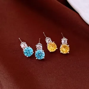Elegant round zircon stud earrings with silver needles in blue and yellow tones.