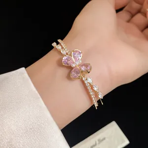 Detailed view of an elegant gold double-layer bracelet featuring a pink zircon butterfly