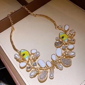 Detail shot of a luxury gold-toned necklace with pearls, rhinestones, and enamel eyes