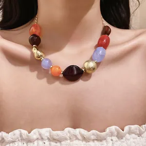 Detailed close-up of a colorful bohemian resin bead necklace worn on a female model's neck