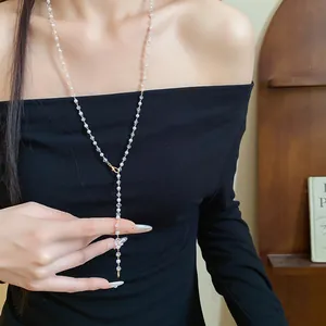 Close-up of elegant pearl beaded Y-necklace worn on a black off-shoulder top