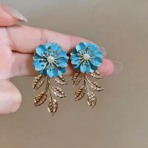 Elegante blaue Emaille-Blumenohrringe mit goldenen Blattquasten und glänzenden Perlen