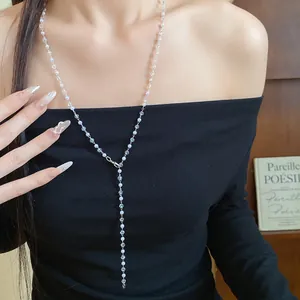 Close-up detail of an elegant faux pearl and crystal beaded Y-shaped necklace on model