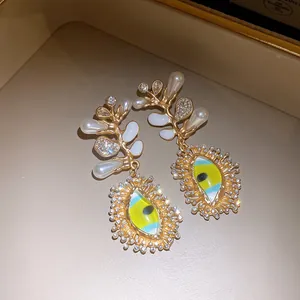 Ornate gold earrings featuring pearls, crystals and lime green enamel eye charms