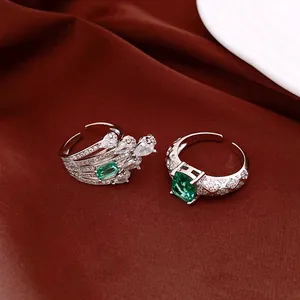 Detailed view of silver open rings with sparkling green emerald-cut and oval zircons