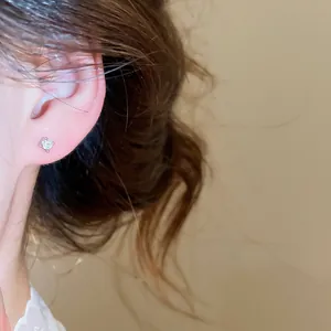 Primo piano di un piccolo orecchino a lobo in zircone scintillante per un look minimalista.