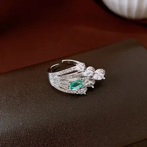 Close-up detail of vintage silver open ring with green and clear zircon gemstones