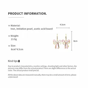 Close-up detail of pink acetic acid bow earrings showing dimensions 8cm by 4.5cm