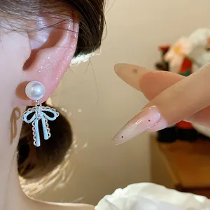 Close-up shot showing the detailed design of a French style bow pearl earring on ear