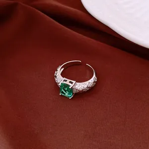 Detailed view of a vintage silver open ring featuring a vibrant green square gemstone