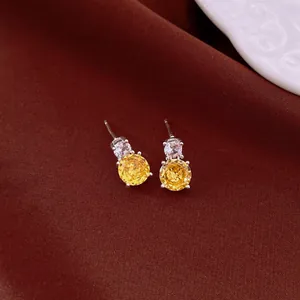 Elegant silver-tone stud earrings with round yellow and clear zircon stones for a luxury look.