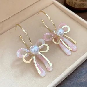 Detailed macro shot of sweet acetate bow earrings with pearls in a jewelry box