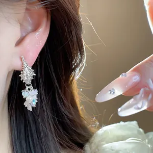 Close-up macro detail of conch shell stud earring featuring pearl and crystal tassels