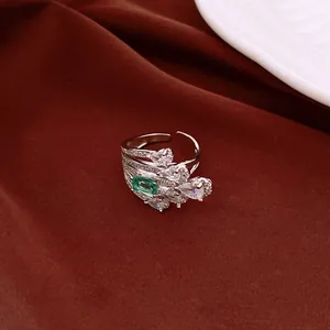 Detailed macro view of a vintage silver adjustable ring featuring green and clear zircons