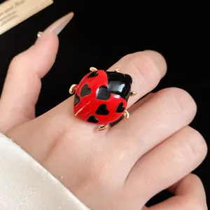 Detail view of ladybug enamel open ring with heart spots on hand, cute animal jewelry.