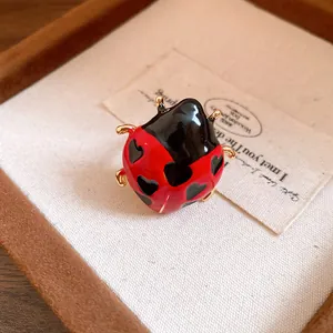 Detailed macro view of enamel ladybug ring featuring heart patterns and gold finish