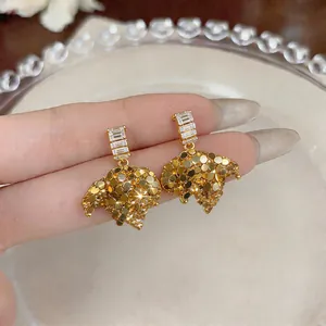 Detailed macro view of golden French-style earrings with sparkling zircon studs.
