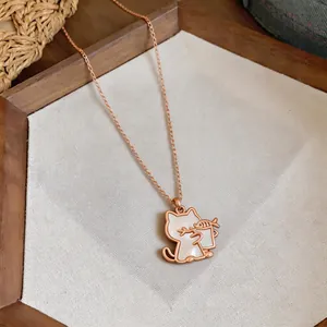 Detail view of a rose gold cat necklace featuring shell inlay and cute fish pendant.