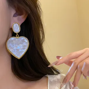 Vintage gold-edged heart resin drop earrings for women shown in close-up detail