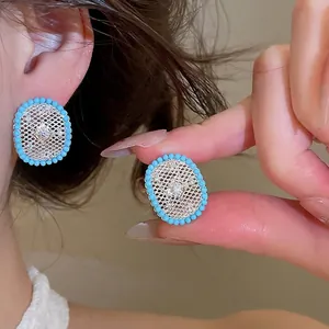 Elegant vintage-style blue beaded oval hollow earrings with sparkling central zircon
